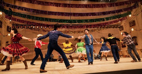 The Company of the National Tour of OKLAHOMA! performs a dance on stage