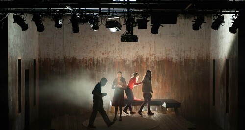 four actors on a dramatically-lit stage